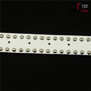 La última correa del cinturón de cuero blanco con hebilla metálica