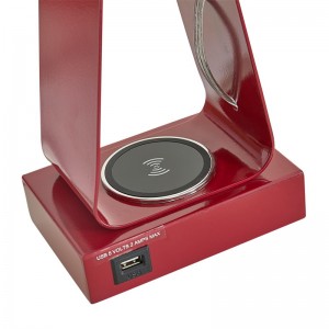 Pequeña lámpara de escritorio con acabado rojo, un puerto de carga USB, una estación de carga inalámbrica y un interruptor de balancín en/off en la sala de visitas